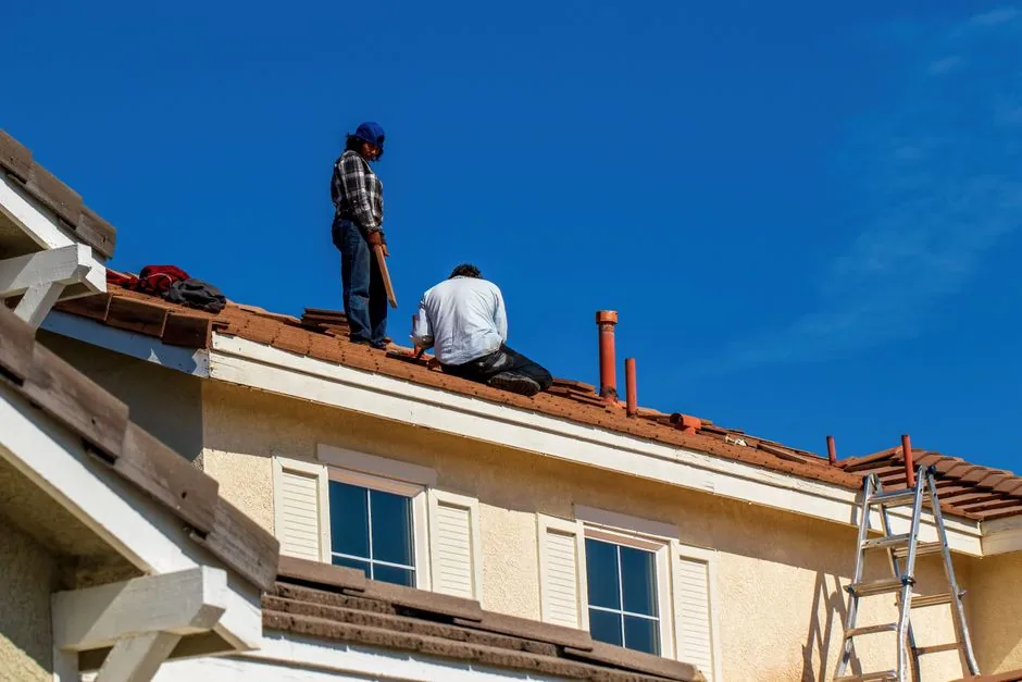 Roofer sealing flashing and drains during a flat roof replacement