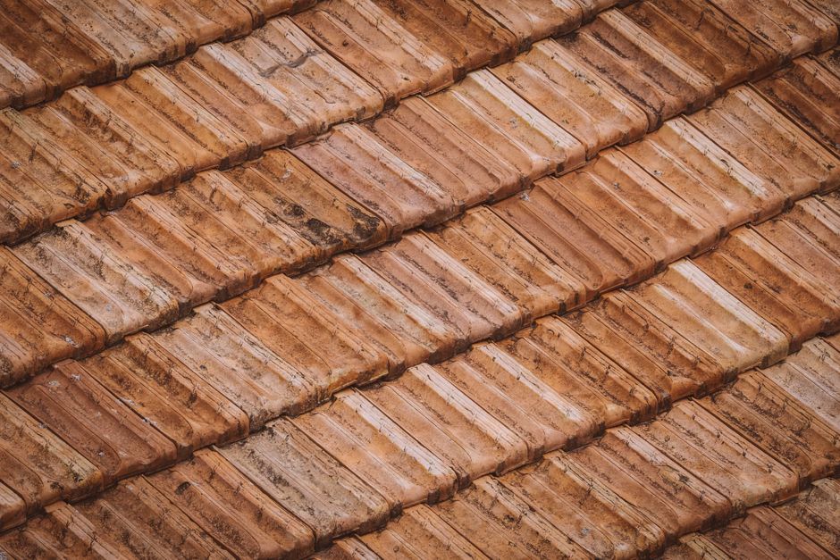 Roofer installing new clay tile roofing on a home in Tempe, AZ