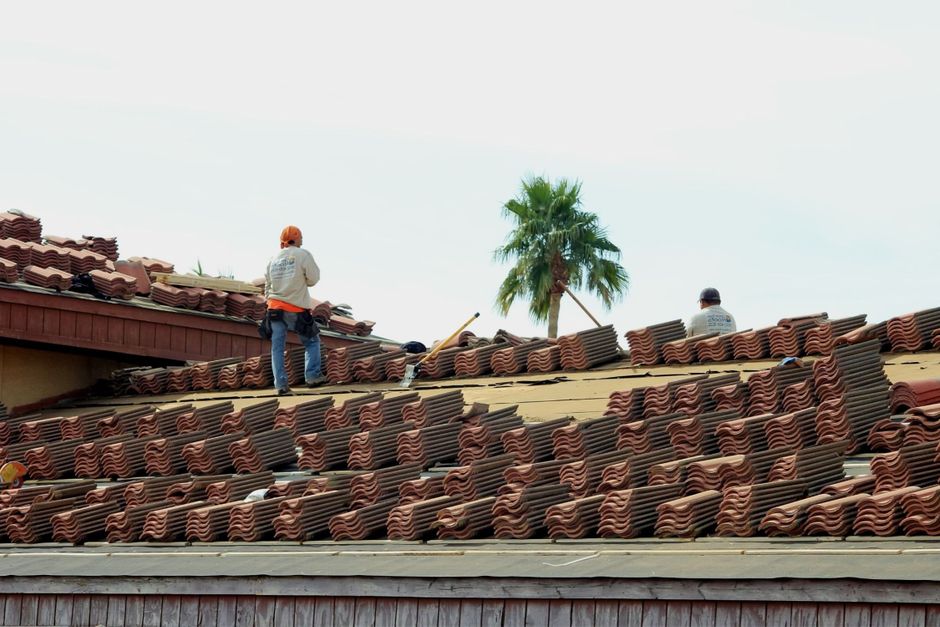Wind storm damage repair underway on a home's roof in Tempe, AZ