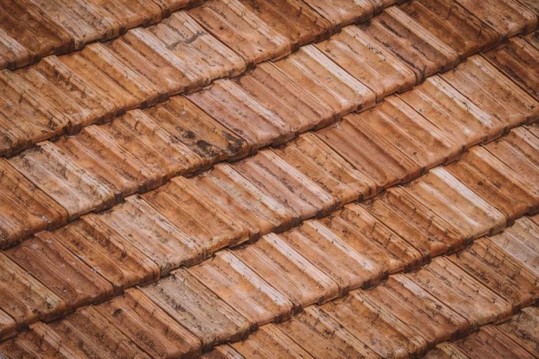 Roofer installing new clay tile roofing on a home in Tempe, AZ, representing a licensed tile roofing contractor at work